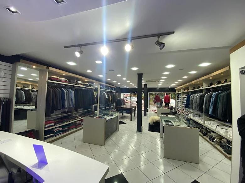 Interior da loja com provador reservado e ambiente em madeira escura